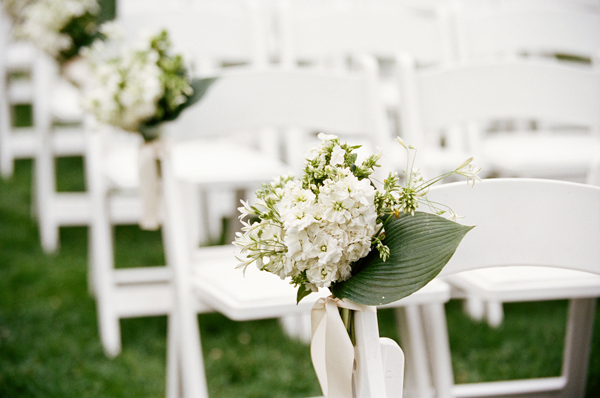 flowers on chairs at the ceremony