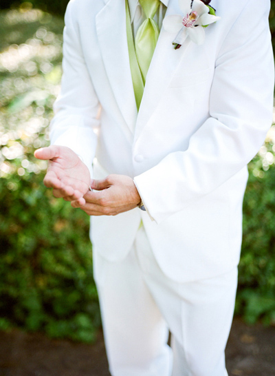 groom wearing white suit